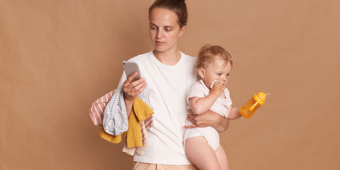 Find mobile parenting resources to support early childhood development Young holding toddler daughter and using mobile phone to find parental resource apps