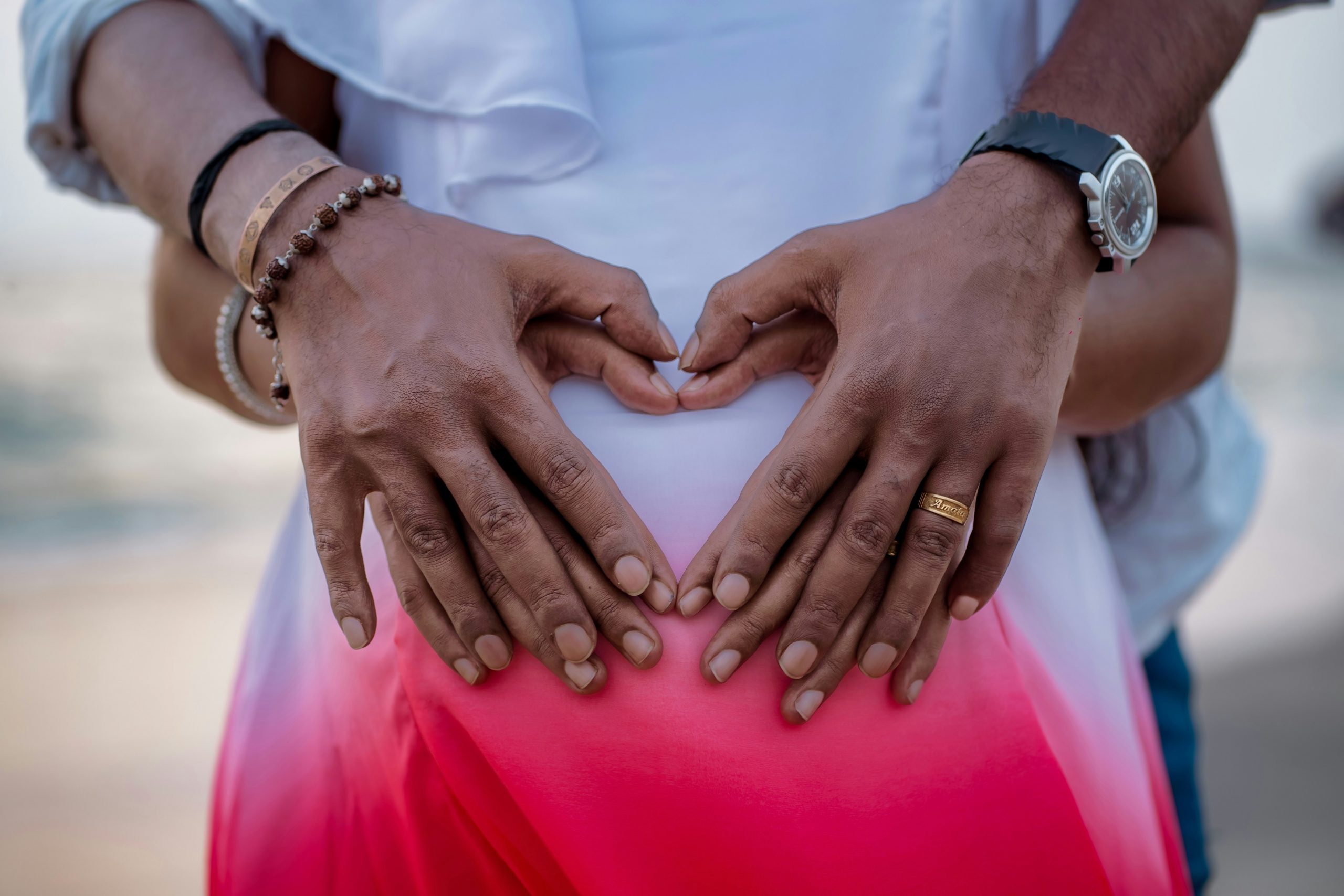 Man embracing hands and stomach of expecting mother, showing support for new pregnancy and a young family