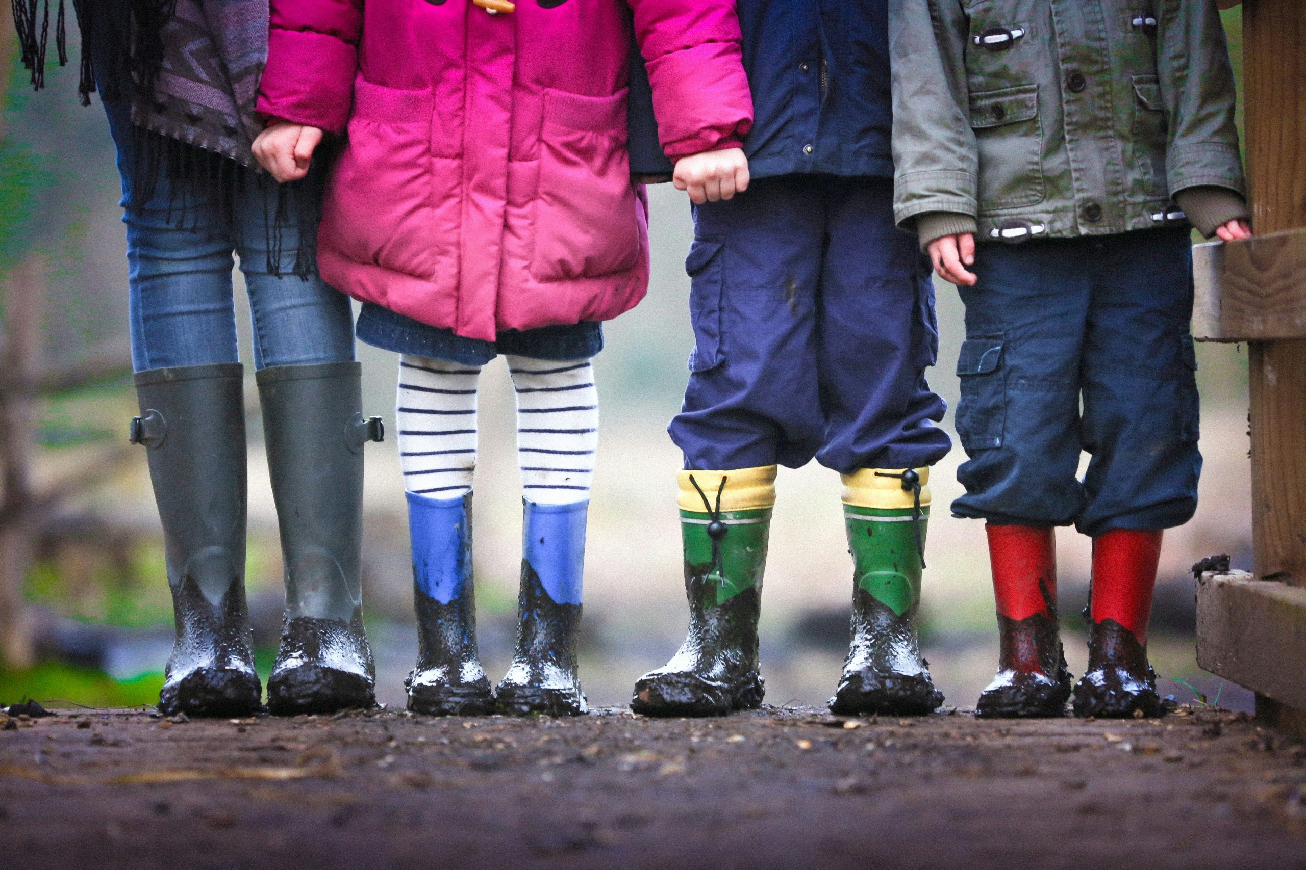 Children dressed for winter in boots and holding hands