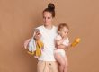Young holding toddler daughter and using mobile phone to find parental resource apps